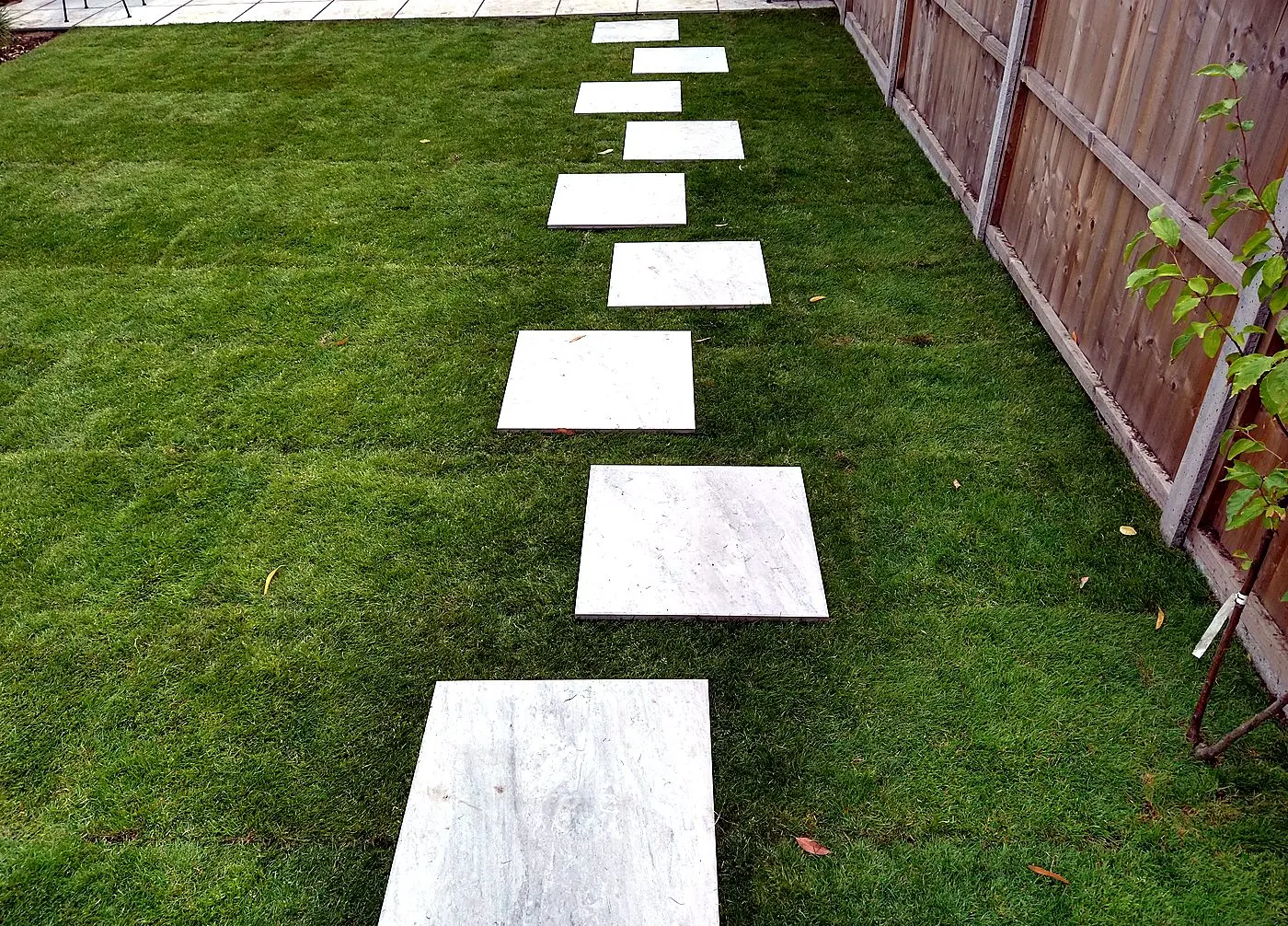 Lap-panel timber fence with concrete posts beside a turfed garden